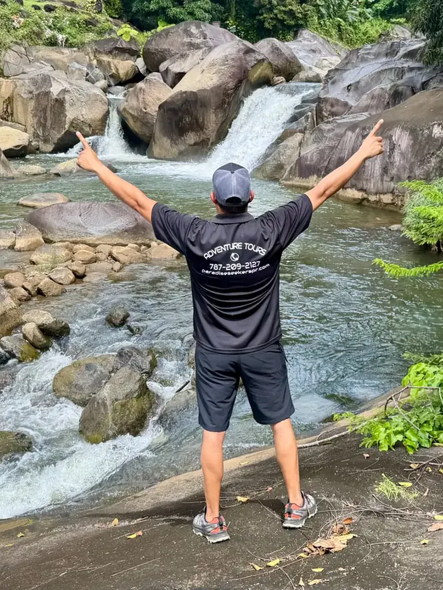 Visitor taking in a rainforest river cascade on a self-guided El Yunque visit
